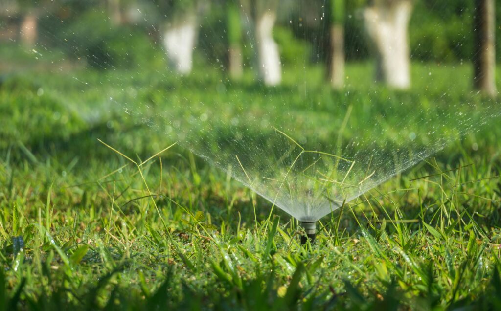 pexels-photo-3351909-3351909 A sprinkler system watering a lush green grass field outdoors during daytime.
